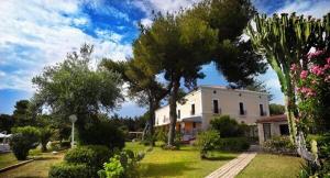 a house in a yard with trees and bushes at Hotel Palazzo Ducale in Diamante