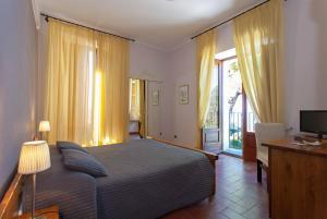 a bedroom with a bed and a desk and a television at Hotel Palazzo Ducale in Diamante