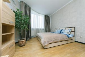 キーウにあるХарьковское шоссе 19аのベッドルーム(ベッド1台、鉢植えの植物付)