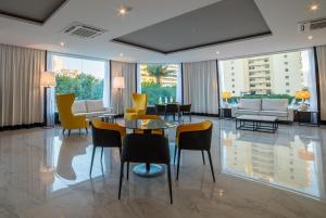 a lobby with yellow chairs and a table at Flor Da Rocha in Portimão