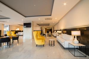 a living room with a couch and chairs and tables at Flor Da Rocha in Portimão
