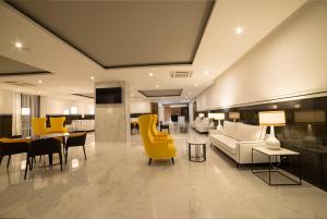 a living room with yellow chairs and tables at Flor Da Rocha in Portimão
