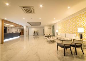a living room with a couch and a table and chairs at Flor Da Rocha in Portimão