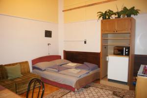ミシュコルツにあるRégiposta Apartmanの小さなベッドルーム(ベッド1台、ソファ付)