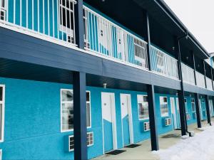 a blue building with white doors and windows at Empire Inn & Suites in Red Deer