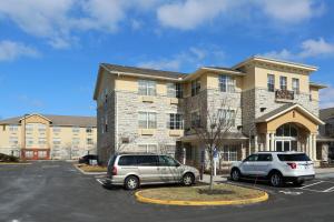 都柏林Extended Stay America酒店 - 哥伦布 - 塔特尔的两辆汽车停在一栋建筑前的停车场