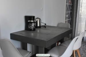 a black table with chairs and a coffee maker on it at Green Point Home Chios in Vrontados