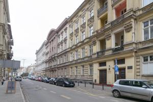 una calle de la ciudad con coches estacionados frente a los edificios en Apartament Kantaka en Poznan