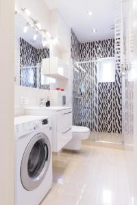 a white bathroom with a washing machine and a sink at Apartament Kantaka in Poznań