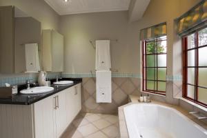 a bathroom with two sinks and a bath tub at The Browns' - Luxury Suites in Dullstroom