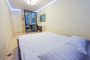 a bedroom with a large white bed and a desk at Апартаменты в центре на проспекте Мира от ApartmentCity in Mogilev