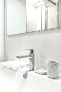 a bathroom sink with a faucet and a cup at La Gloriette in Annecy