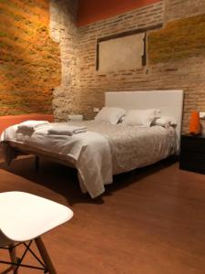 a bedroom with a bed and a brick wall at Hosteria Natura Plaza in Segovia