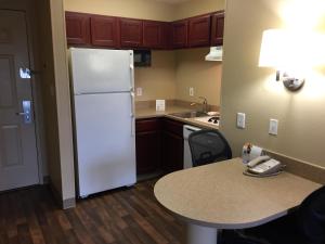 a kitchen with a white refrigerator and a table at Extended Stay America Suites - Memphis - Wolfchase Galleria in Memphis