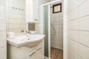a white bathroom with a sink and a shower at Apartments Urban Porec in Poreč +21 photos