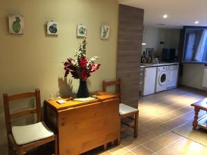 una cocina con una mesa con un jarrón de flores. en El Baluard, en Cardona