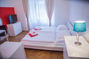 a bedroom with a white bed with red towels on it at Budget Apartment in Prague