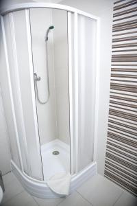 um chuveiro com uma porta de vidro na casa de banho em Budget Apartment em Praga