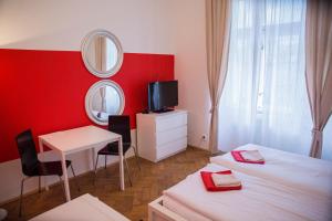 a room with two beds and a table and a mirror at Budget Apartment in Prague