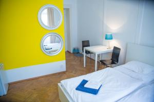 a bedroom with a white bed and two mirrors at Budget Apartment in Prague