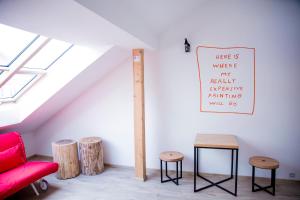 a living room with a red couch and stools at Gregory House in Prague