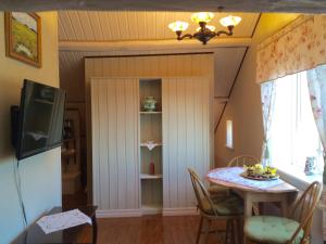 a dining room with a table and a tv at Tavlebords Honungsgård in Tegneby
