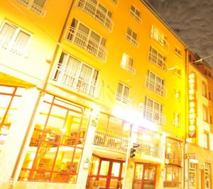 un gran edificio amarillo con ventanas en una calle en Hotel Santo en Karlsruhe
