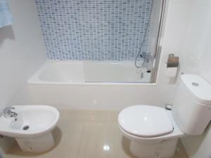 a white bathroom with a toilet and a sink at Lo Xalador-Delta d'Ebre in Deltebre