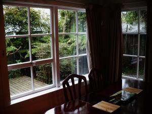a table and chairs in front of a window at Brockworth Cottage in Christchurch