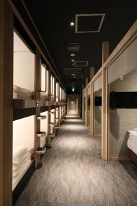 a row of bunk beds in a room at Cabin & Capsule Hotel J-SHIP Osaka Namba in Osaka