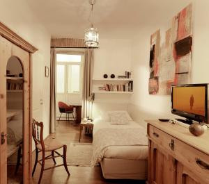 Schlafzimmer mit einem Bett, einem TV und einem Schreibtisch in der Unterkunft Boutique Hotel Albero Nascosto in Triest