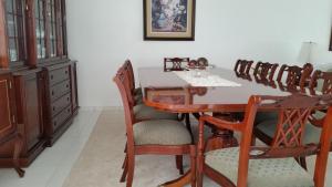 una sala da pranzo con tavolo e sedie in legno di Casa de Leny cerca de la Feria Exposición a Santa Cruz de la Sierra