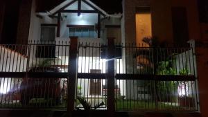 a fence in front of a house at night at Casa de Leny cerca de la Feria Exposición in Santa Cruz de la Sierra