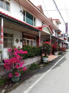 a building with pink flowers on the side of a street at Golden flower Homestay in Yuli