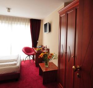 a hotel room with a bed and a table with flowers at Hotel Santo in Karlsruhe
