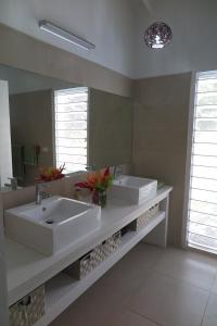 a bathroom with two sinks and a large mirror at Ocean Point Villa in Saraotou