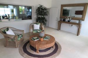 a living room with a coffee table and two chairs at Ocean Point Villa in Saraotou