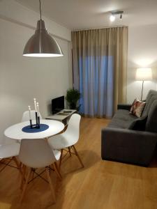 a living room with a couch and a table and chairs at ML Apartments Avenue in Porto