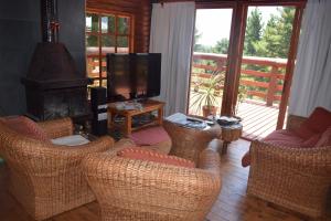 a living room with wicker chairs and a flat screen tv at lodge con piscina privada, parcela de campo. in Algarrobo