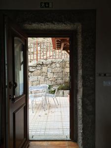 a door leading to a patio with a table at Casa de São Sebastião in Manteigas