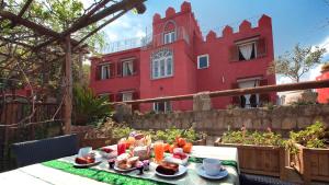 a table with food on it in front of a red building at Albergo 'La Vigna' in Procida