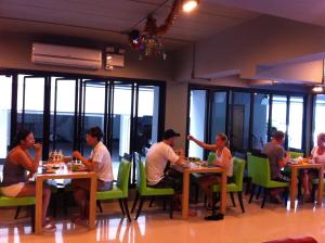 a group of people sitting at tables in a restaurant at The BluEco Hotel SHA Plus in Kata Beach