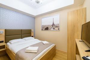 um quarto com uma cama e uma fotografia da Torre Eiffel em Teplo Hotel em Vladivostok
