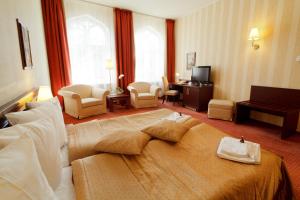 a hotel room with a large bed and a living room at Monika Centrum Hotels in Riga