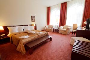 a hotel room with a large bed and chairs at Monika Centrum Hotels in Riga +90 photos