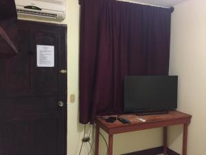 a room with a television on a table next to a door at AC Room 2 Persons Hospedaje Don Wilfredo in San Juan del Sur