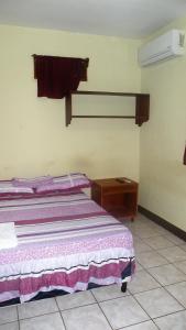 een slaapkamer met een bed en een houten tafel bij AC Room 2 Persons Hospedaje Don Wilfredo in San Juan del Sur