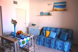 a living room with a table and a couch at Airone Bianco Residence Village in Lido delle Nazioni