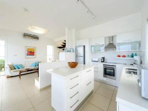 uma cozinha com armários brancos e uma sala de estar em “Your Luxury Sea Front Villa” – Protaras Villa 01 em Protaras
