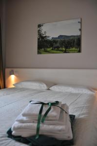 Una cama blanca con toallas encima. en Bed & Breakfast Vieulif, en Moniga del Garda